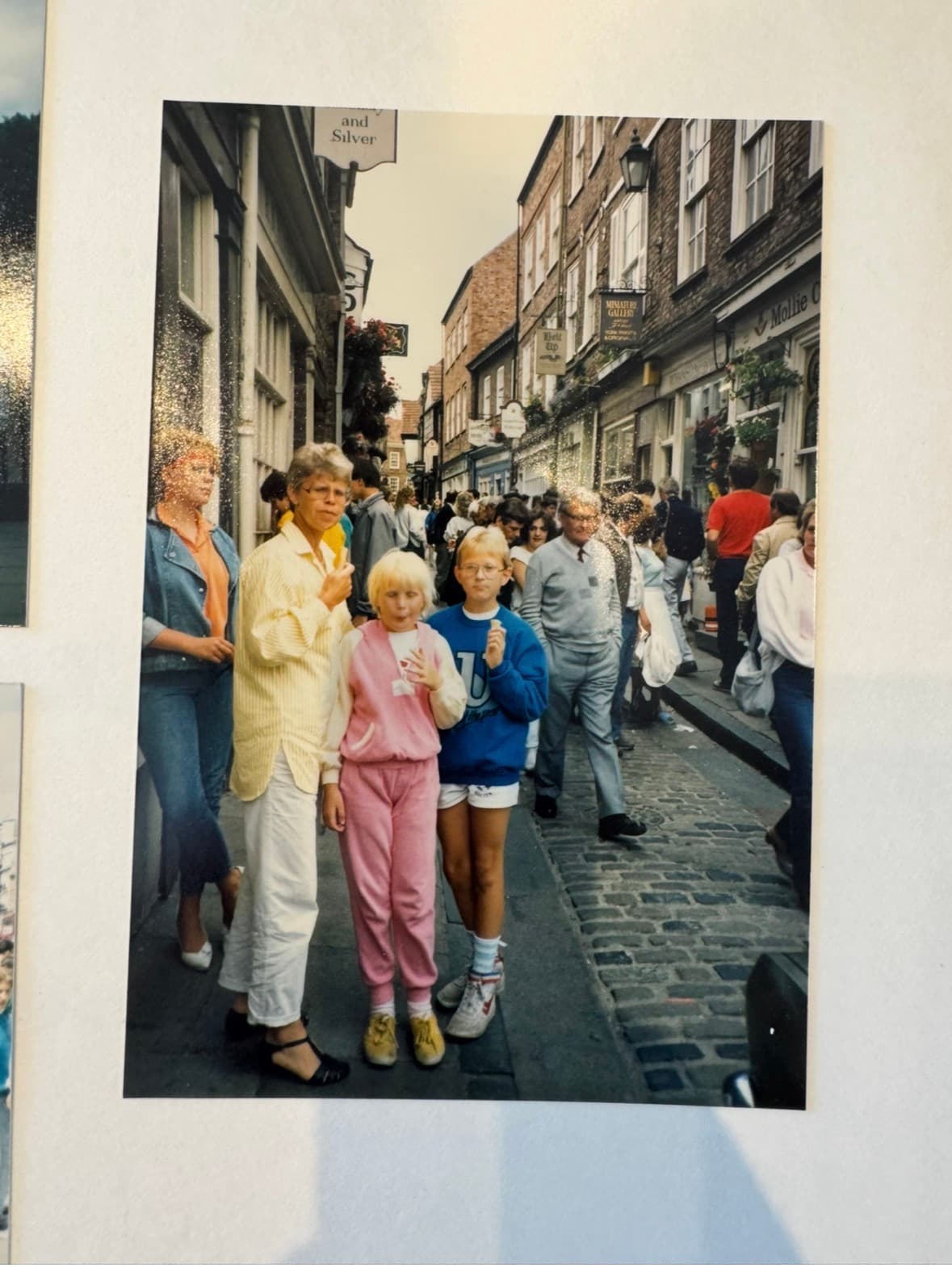 Originalfotot: en kvinna och två barn med glass i händerna på en kullerstensgata i Storbritannien, 1986.